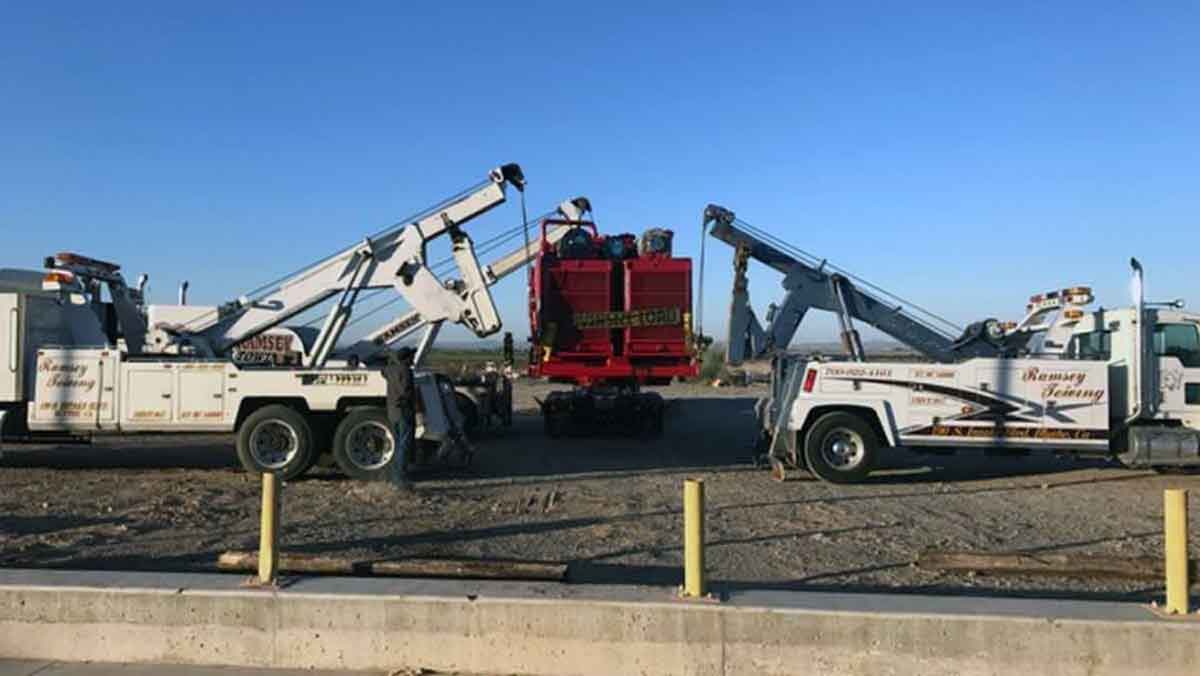Ramsay Towing cranes lifting oversized load onto bed of a truck