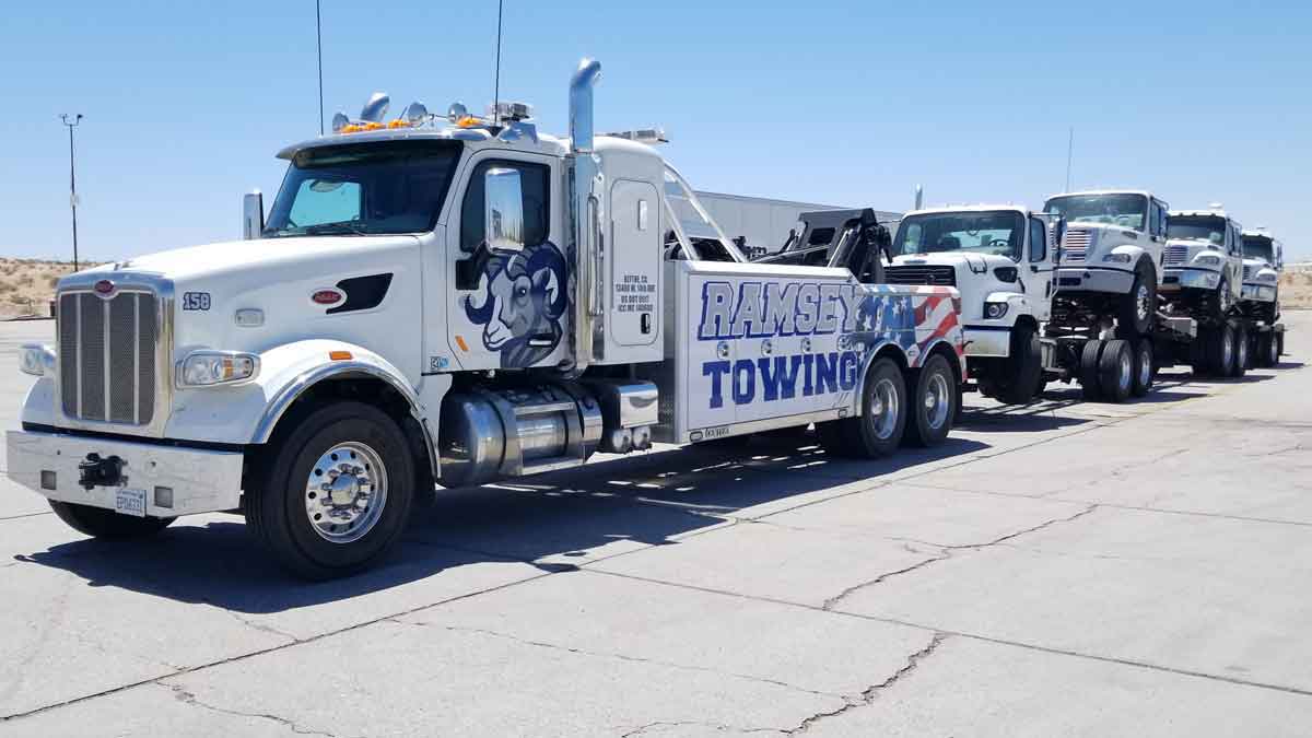 Ramsey Towing truck hauling 4 trucks